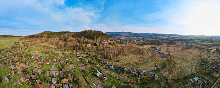 Mountain village among green fields, aerial view.