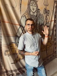 Portrait of young man standing against wall