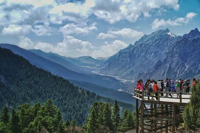 Tourists at observation point against mountains