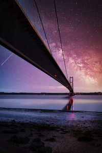 Bridge over sea against sky at night