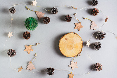 Christmas background, garland, pine cones, decorations and cut of a tree trunk on a gray