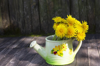 Close-up of yellow flower pot on table