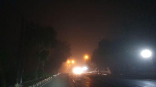 Illuminated street lights on road at night