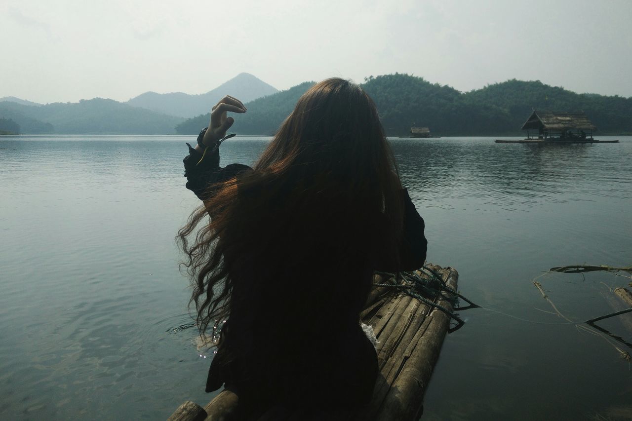 water, lake, lifestyles, leisure activity, sky, tranquility, nautical vessel, rear view, nature, sea, tranquil scene, men, mountain, scenics, person, reflection, beauty in nature, sitting