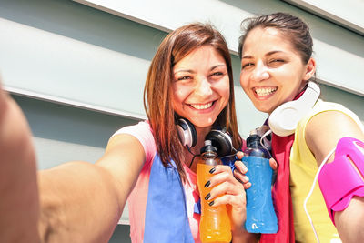 Portrait of smiling young woman holding camera