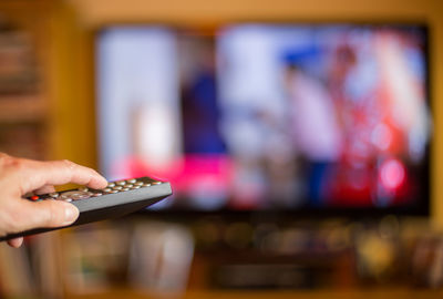 Close-up of woman holding remote control