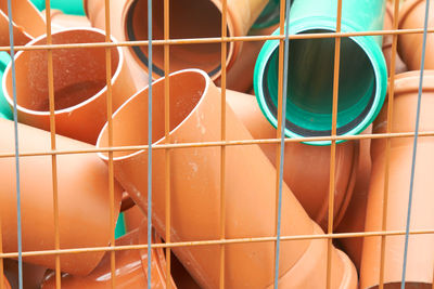 Full frame shot of multi colored pipes seen through metal grate
