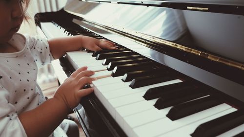 Midsection of child playing piano