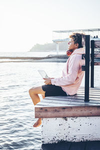 Young man relaxing on pier during weekend