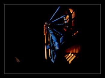 Close-up of illuminated lighting equipment against black background