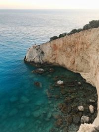 Rock formation on sea shore against sky