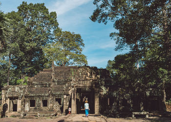 Rear view of mid adult woman walking at ankor wat temple