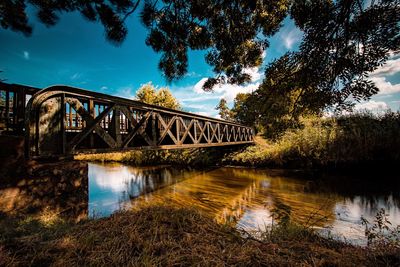 Arch bridge over river against sky