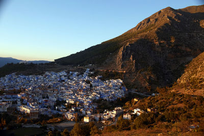 Town by mountains against clear sky