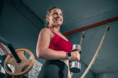 Young woman with dumbbells in the gym. portrait of young attractive woman  doing fitness workout