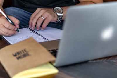 Midsection of man using laptop on table