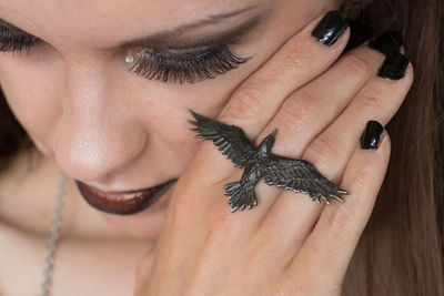 Close-up of young woman showing bird ring