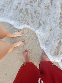 Low section of people standing on beach