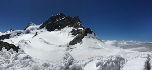 Scenic view of snowcapped mountains against clear blue sky