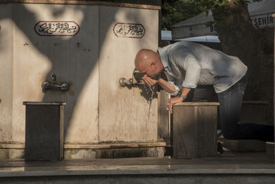 Man working against wall