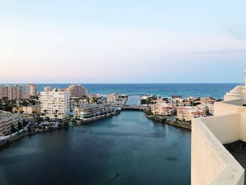 High angle view of buildings by sea against sky