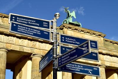 Low angle view of road sign by brandenburg gate
