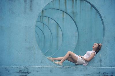 Full length side view of woman lying in circle shaped built structure