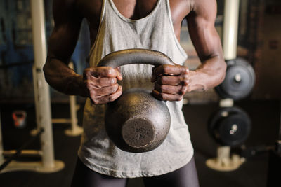 Male athlete lifting kettlebell at gym