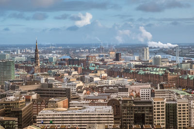 View of cityscape against cloudy sky