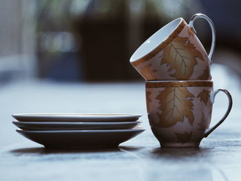 Stack of teacups and saucers on table