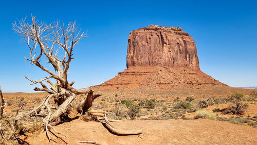 Rock formations on landscape against clear blue sky