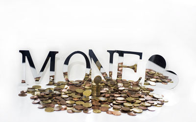 Close-up of coins on table against white background