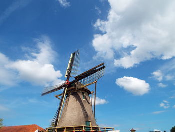 Low angle view of windmill against cloudy sky