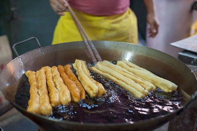 Midsection of man preparing food in cooking utensil