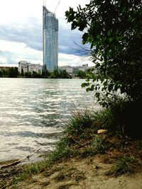 River by buildings against sky