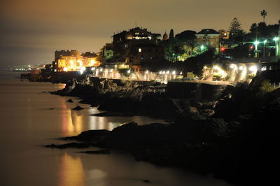 Illuminated city at waterfront at night