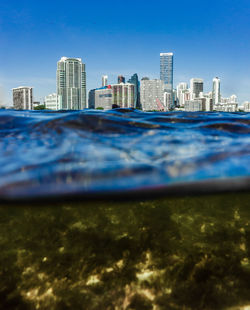 View of skyscrapers in city against blue sky