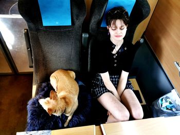 Woman with dog sitting at home