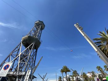 Low angle view of ferris wheel against blue sky