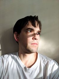 Portrait of young man against wall at home