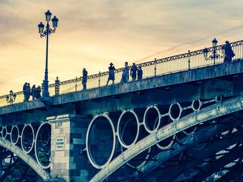 People on bridge against sky in city