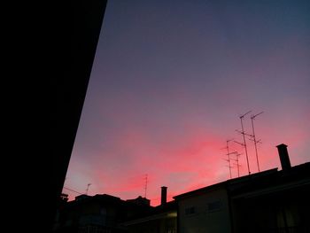Low angle view of illuminated city against sky at night