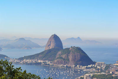 Scenic view of sea and city against clear sky