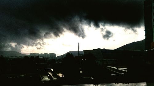 View of cityscape against storm clouds