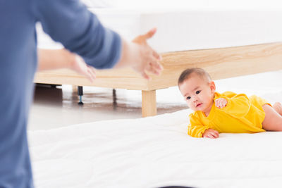 Midsection of woman playing with toys on bed at home