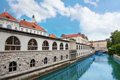 View of canal amidst buildings against sky