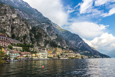 Scenic view of lake by buildings against sky