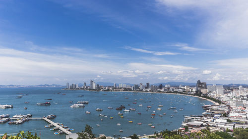 High angle view of city by sea against sky