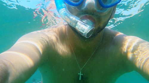 Close-up of young man swimming in pool