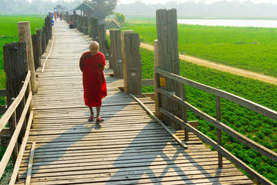 Rear view of woman walking on footpath